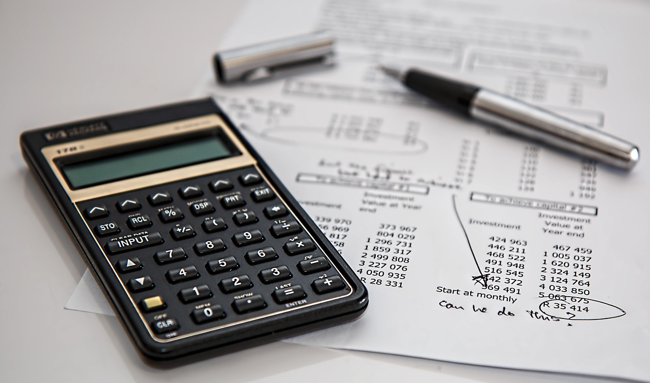 Calculator resting on financial documents showing rebate and tax figures