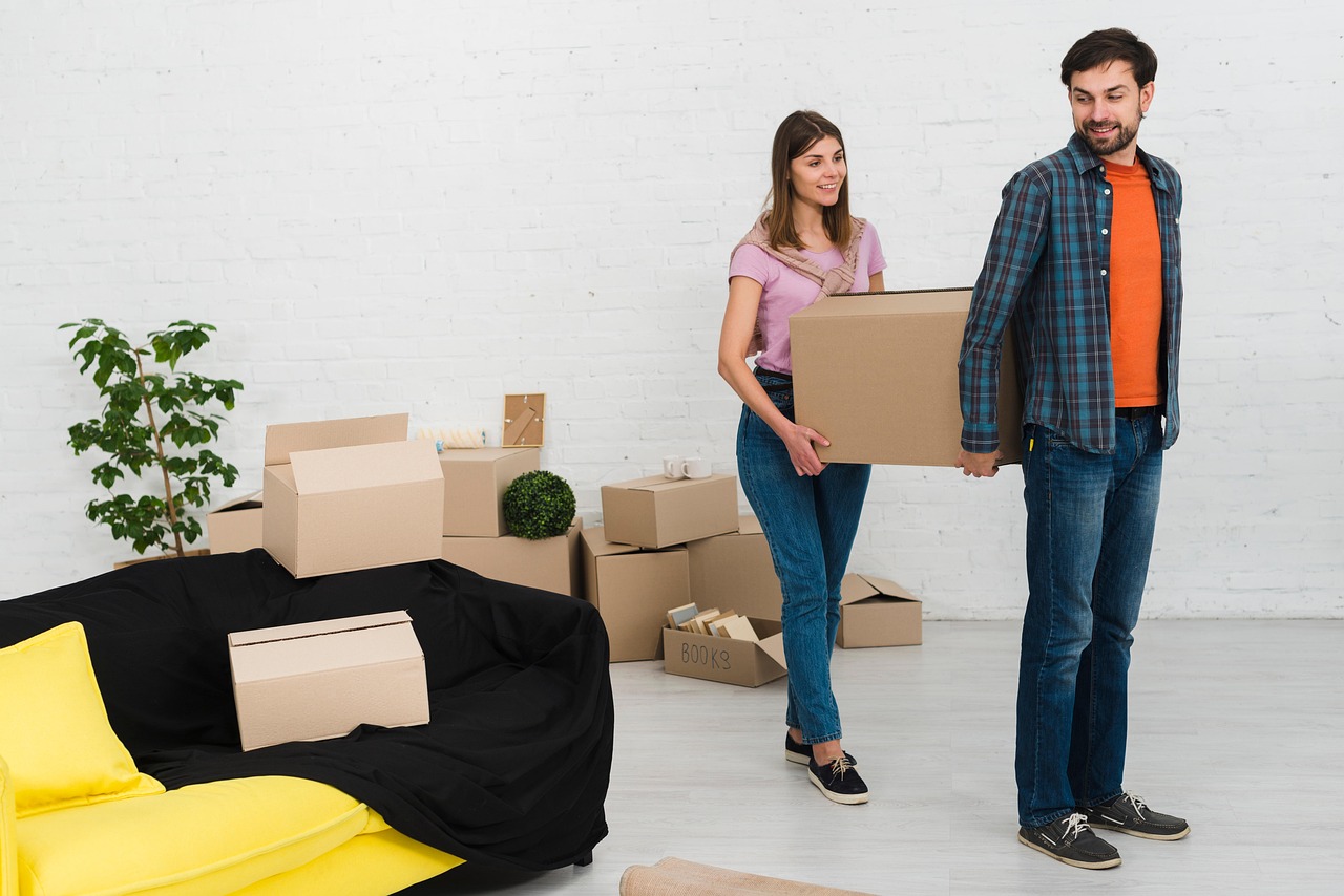 Professional movers loading wrapped furniture and boxes into a moving truck